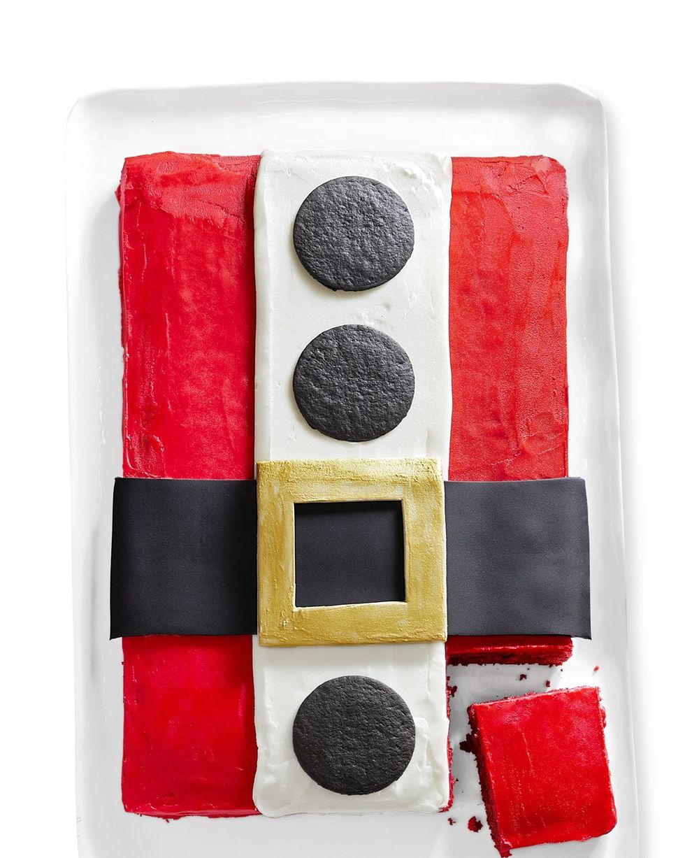rectangle sheet cake with red frosting and a white stripe of frosting down the middle with chocolate cookies for buttons and a belt over the middle to look like santas coat