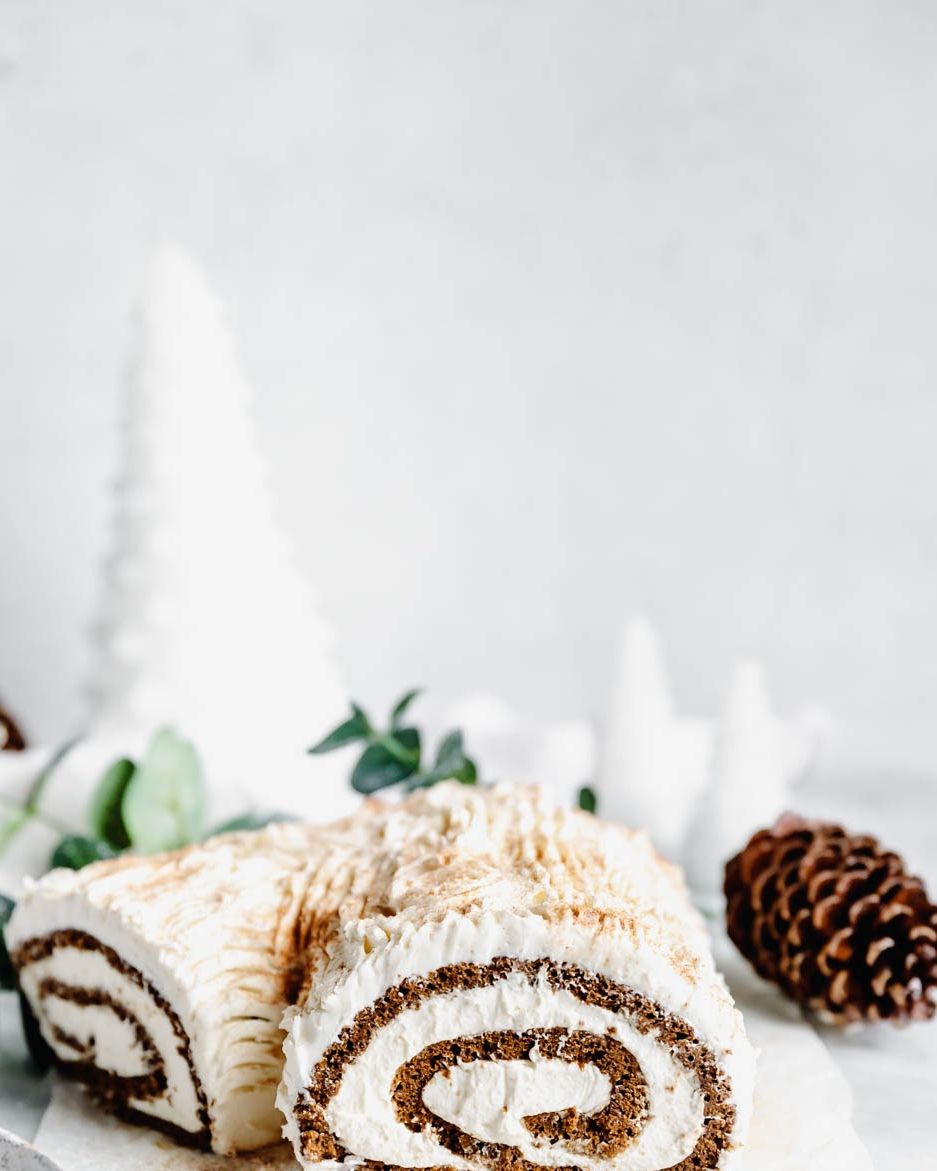 gingerbread yule log filled with whipped cream and topped with white chocolate buttercream