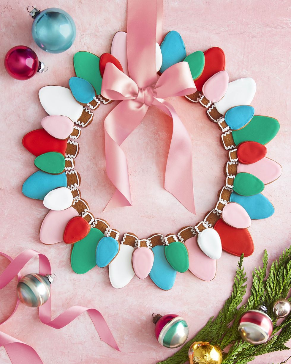 christmas light gingerbread cookies arranged in the shape of a wreath with a pink bow