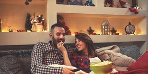 christmas couple looking movie and eat popcorn in bed