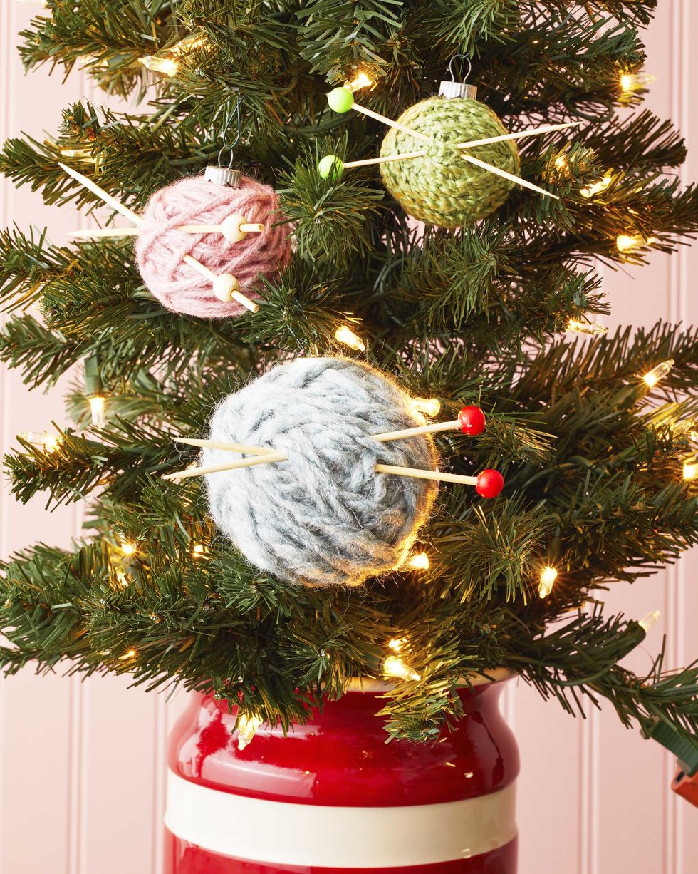mini yarn balls with toothpick knitting needles hung on a christmas tree