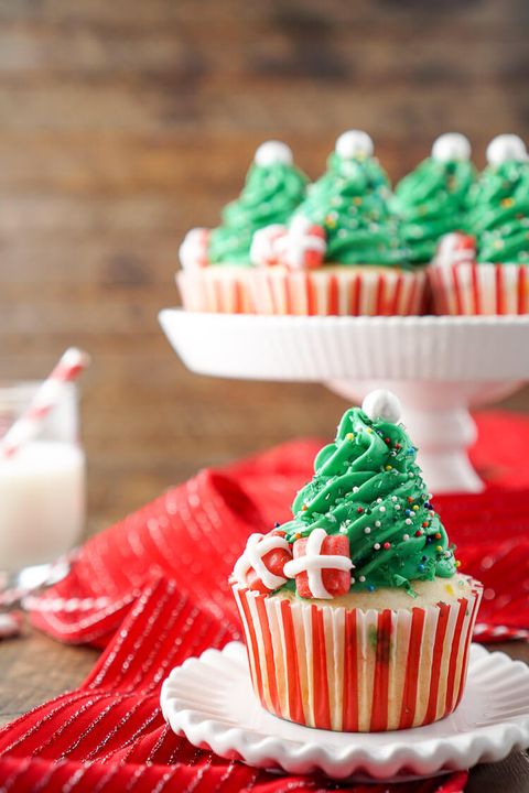 christmas tree cupcakes with one on white plate in front