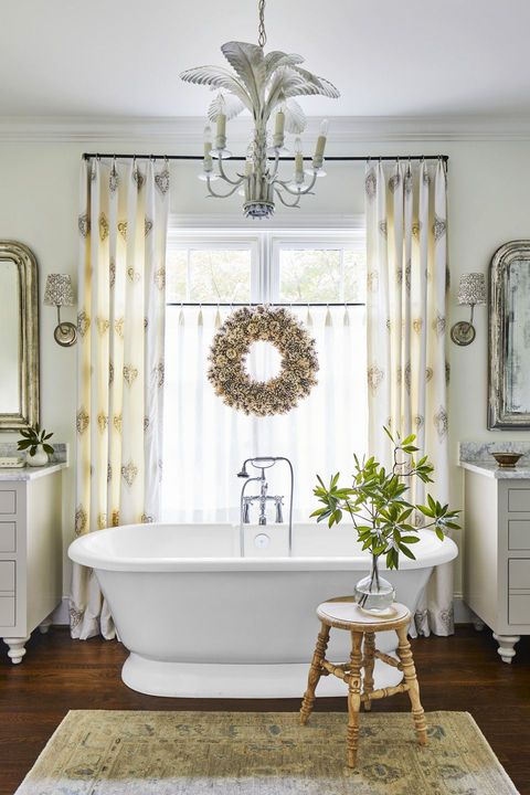 bathroom with gold wreath over tub
