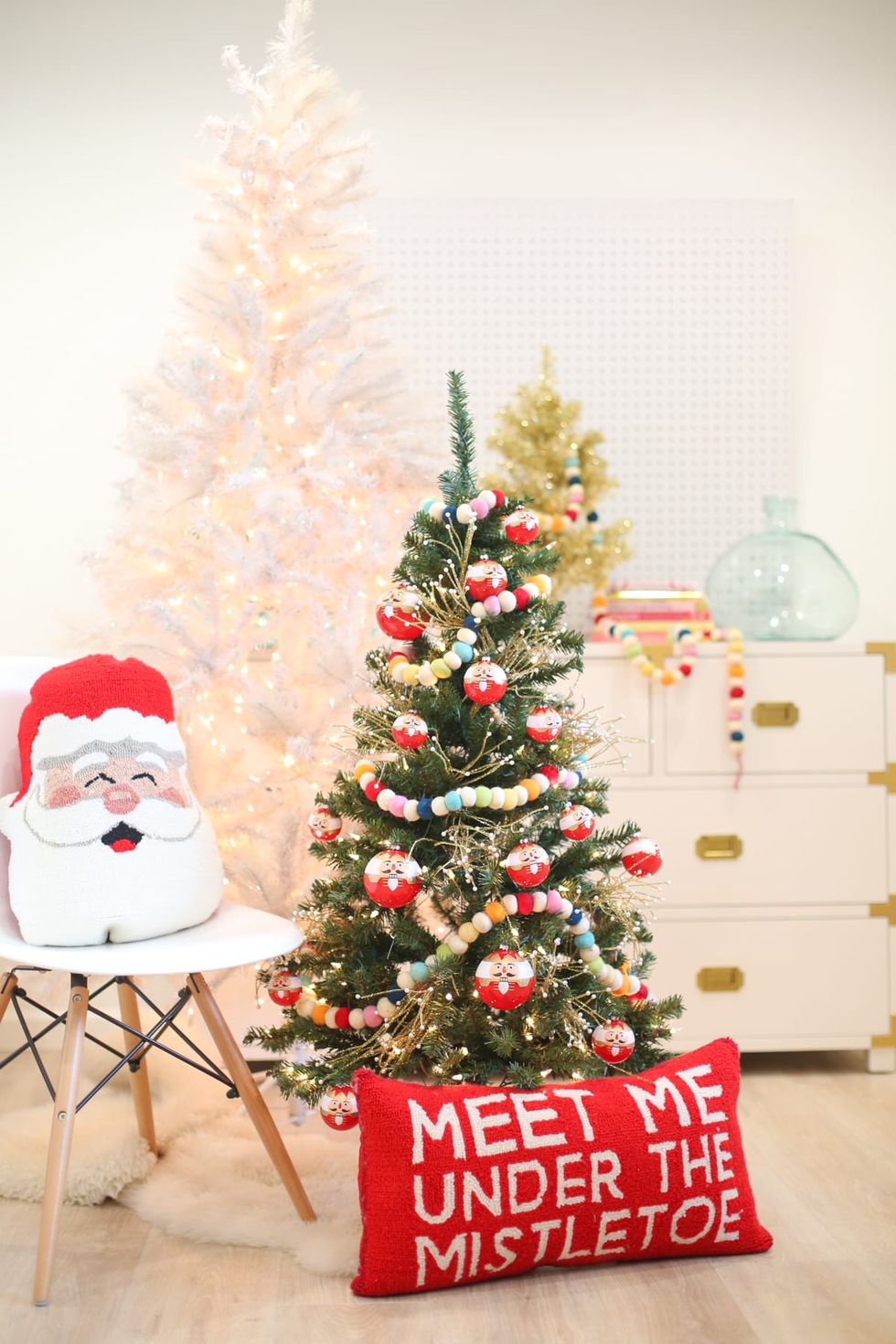 a christmas tree with a santa clause hat and a white chair