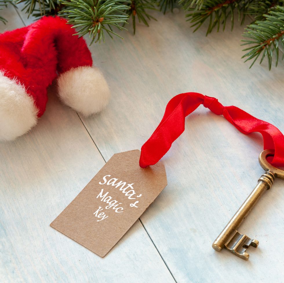 christmas activities santas magic key and santa hat close up on light blue wooden background