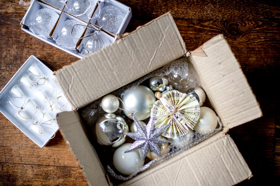 white and silver christmas decorations in cardboard box with bubble wrap