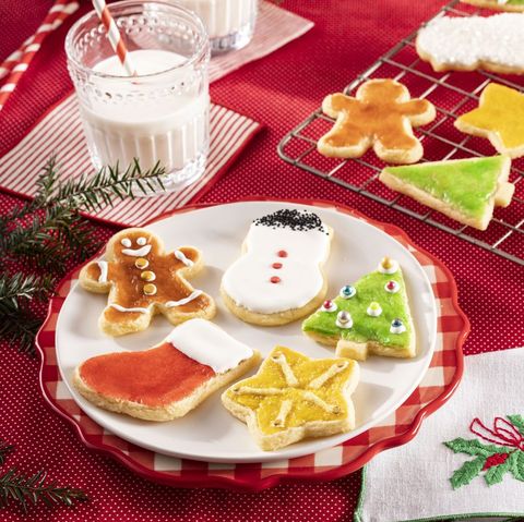 christmas cookies on plate with glass of milk and red background