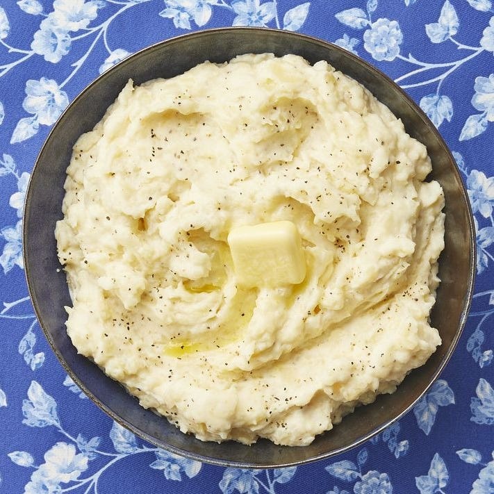 instant pot mashed potatoes with butter on blue surface