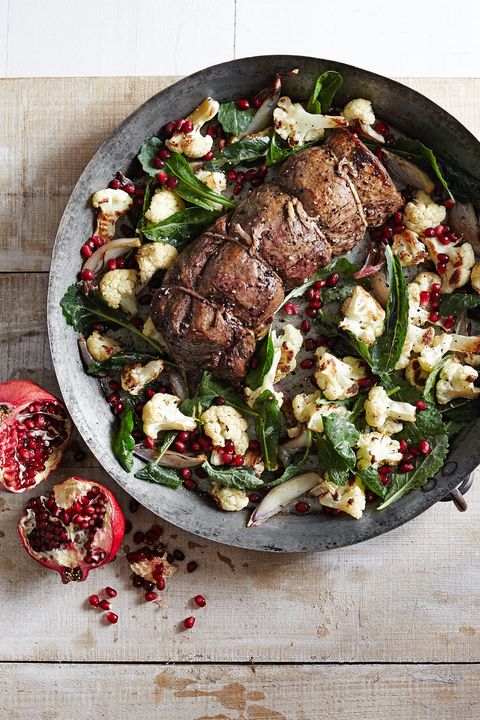 beef tenderloin with roasted cauliflower salad on a metal plate on a wooden table