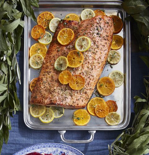 christmas dinner ideas citrus roasted salmon on a silver serving tray with sliced citrus fruits and thyme