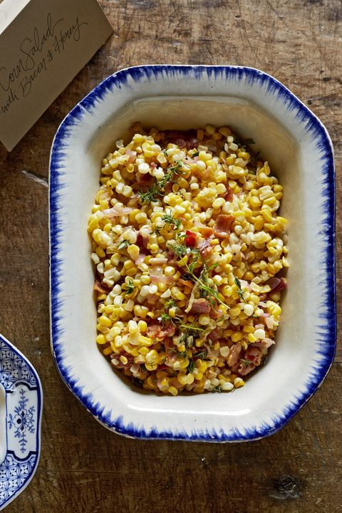 corn bacon salad in a white oval serving bowl with blue trim