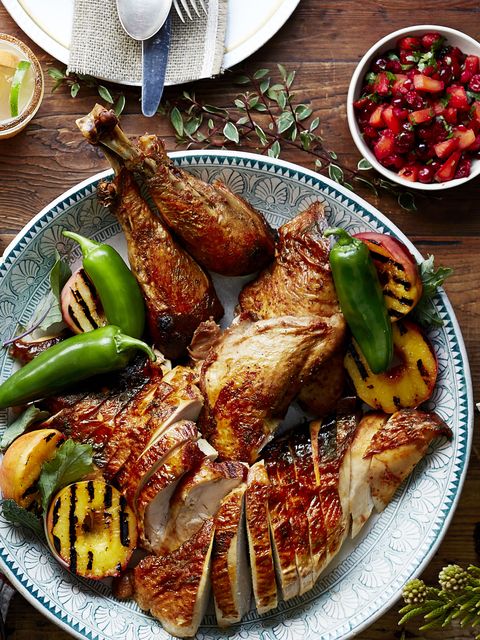 sliced deep fried turkey arranged on a serving plate with peppers and grilled apricots