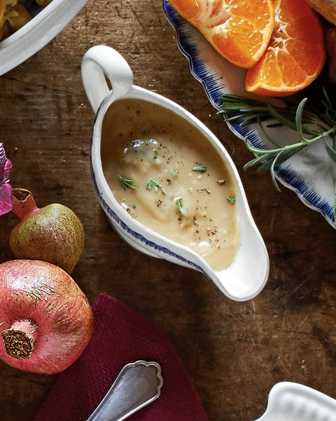 white wine and rosemary gravy in a gravy boat on a set table