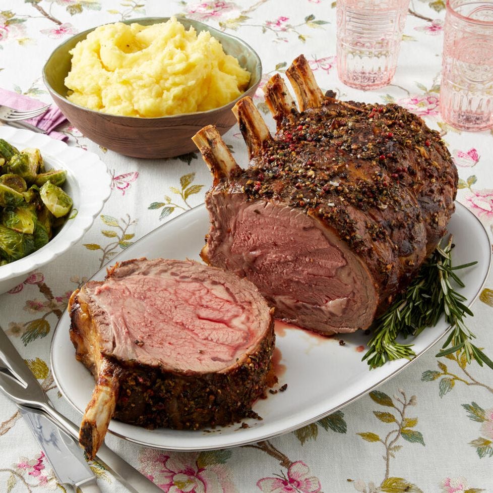 christmas dinner menu prime rib on white platter with mashed potatoes in back