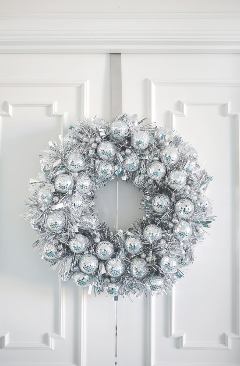 christmas door decorations, wreath made of disco balls hanging on the white door