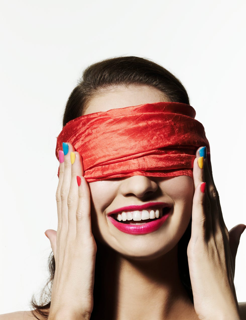 girl with bright nail polish blinded with a red scarf covering her eyes