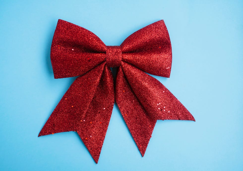 big sparkly red christmas bow decoration on blue background