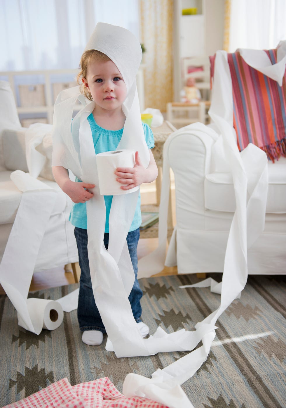 little girl wrapped in toilet paper standing in living room
