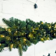 christmas garland with lights and stars on fireplace mantel