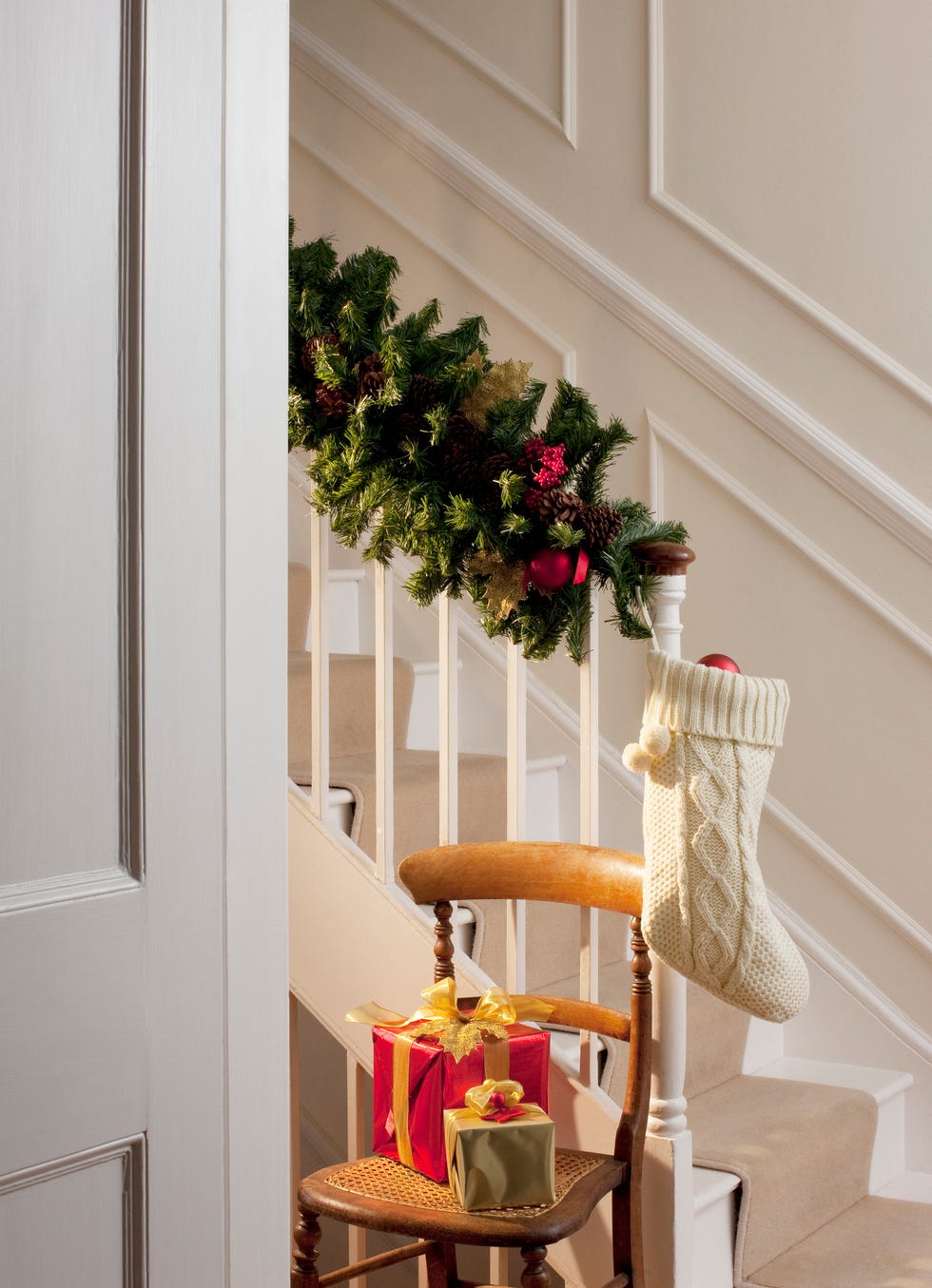christmas gifts and stocking near staircase