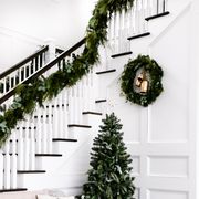 how to hang garland, domestically blissful stairwell with garland and small christmas tree