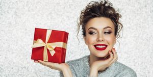 Christmas happy smiling young woman holds gift box in hands