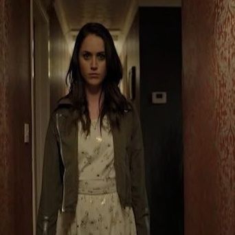 a woman walks down a hallway with a menacing look on her face in a scene from hosts