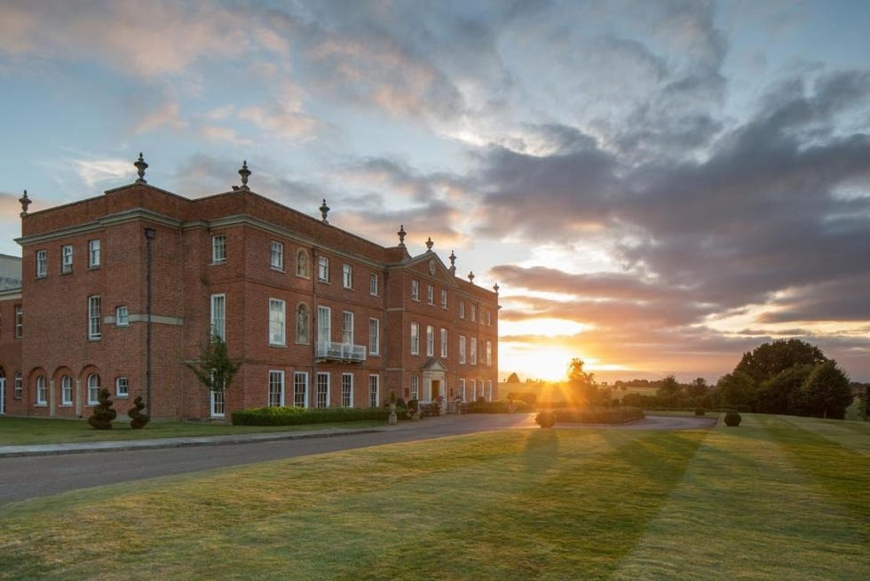 a large brick building with a green lawn in front of it