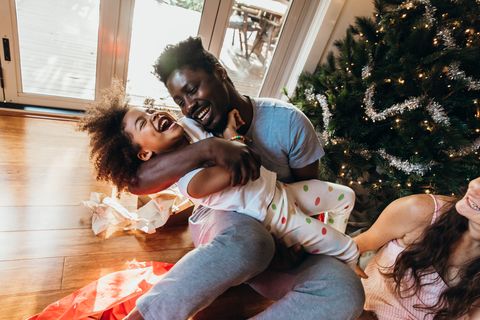 young australian father cuddles and laughs with his daughter after opening presents on christmas morning