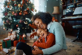 mother and daughter laughing and having fun while spending christmas together at home
