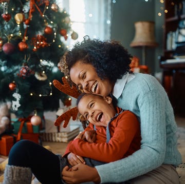 christmas jokes - mother and daughter laughing and having fun while spending christmas together at home mother and daughter laughing and having fun while spending christmas together at home