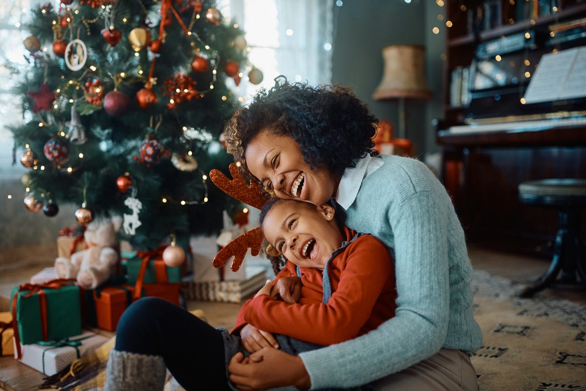 mother and daughter laughing and having fun while spending christmas together at home