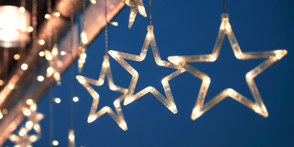 star christmas lights hanging against blue sky