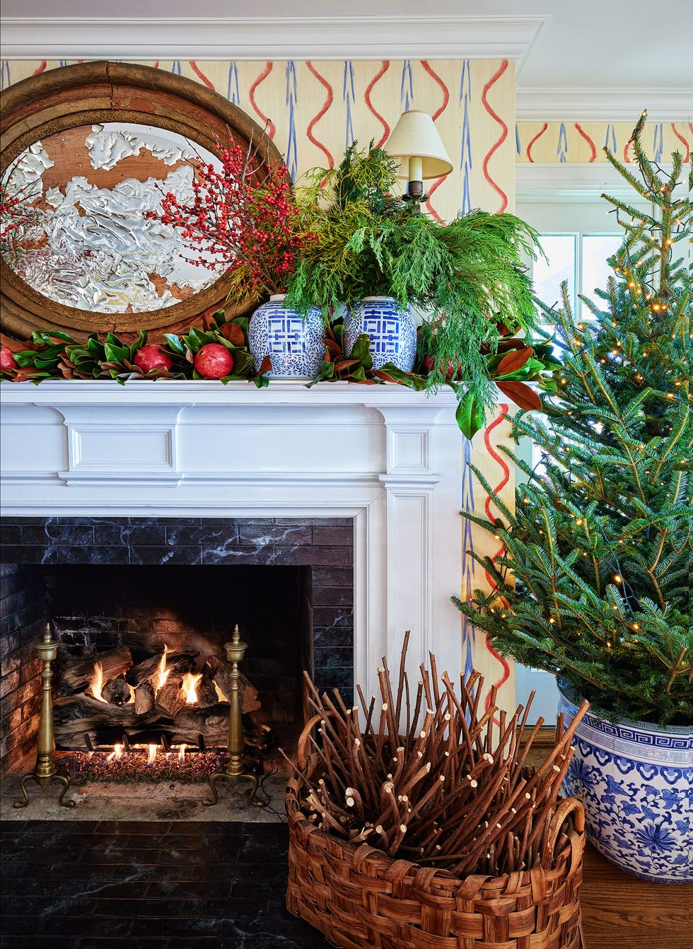 a fireplace with a christmas tree and a basket of fruit
