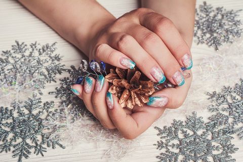 winter nail art with snowflakes and light blue french on wooden background