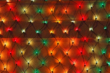 a decorative arrangement of string lights is displayed in a net pattern against a wall