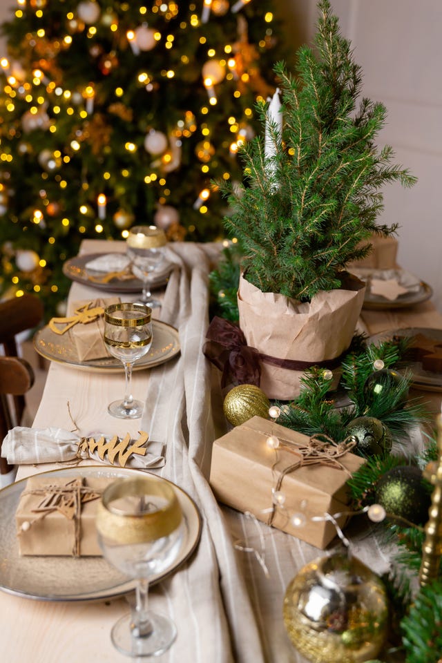 christmas or new year decoration of the festive table table setting with dishes spruce tree decoration