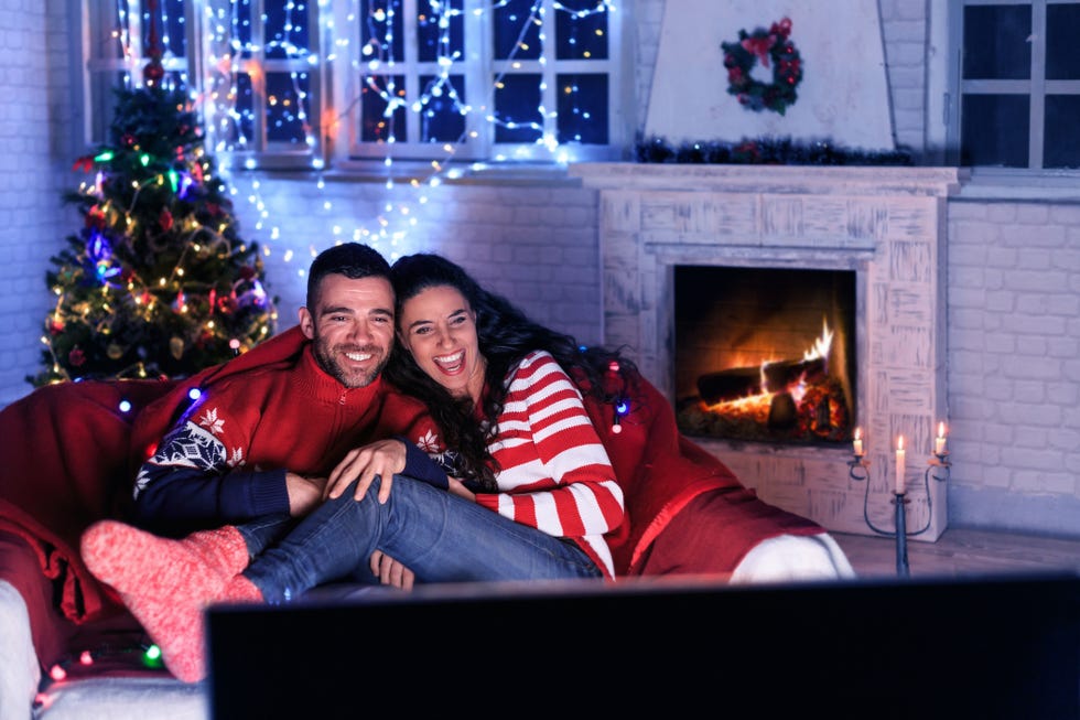 man and woman watching movies at christmas time