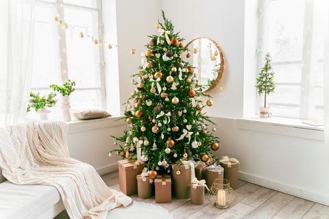 white and spacious domestic living room decorated with christmas fir tree and pastel holiday decor