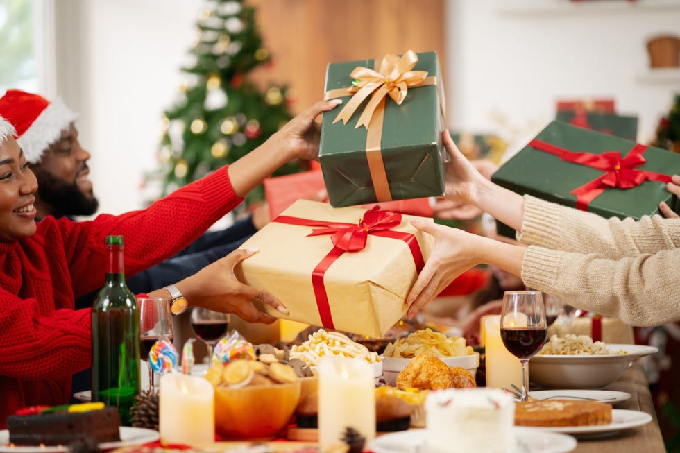 a group of adults exchanging wrapped christmas presents