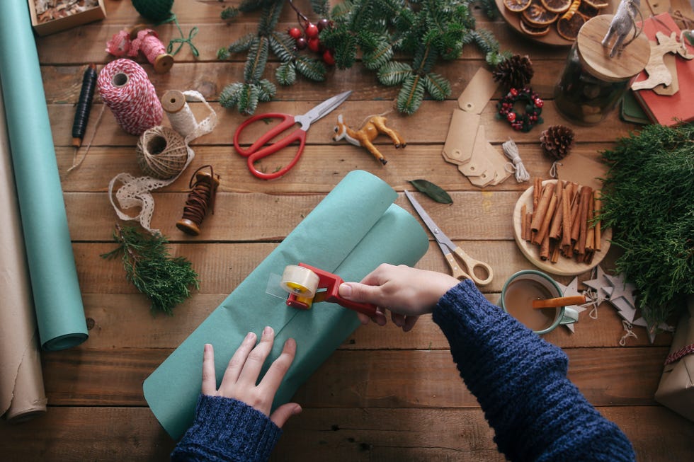 two hands wrapping a christmas present