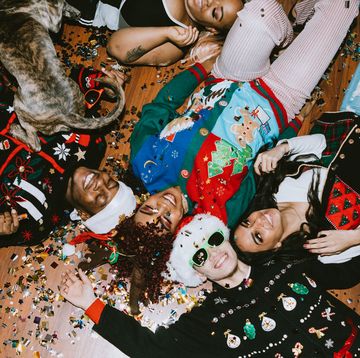 christmas party themes where friends are laying on the floor covered in glitter, while wearing holiday themed accessories