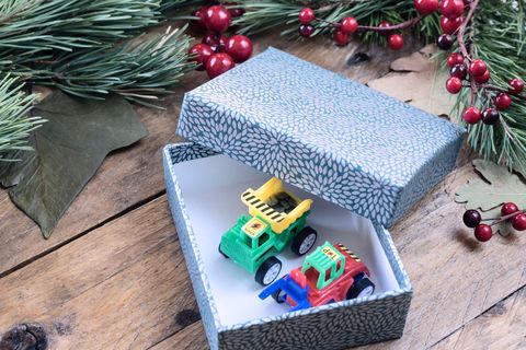 christmas party themes a box open with two toy trucks inside