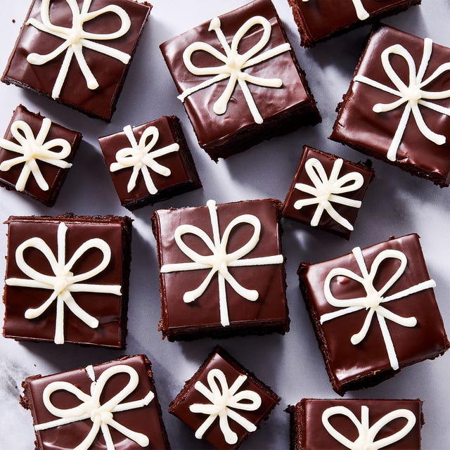 small brownies decorated with chocolate ganache and white icing to look like christmas presents