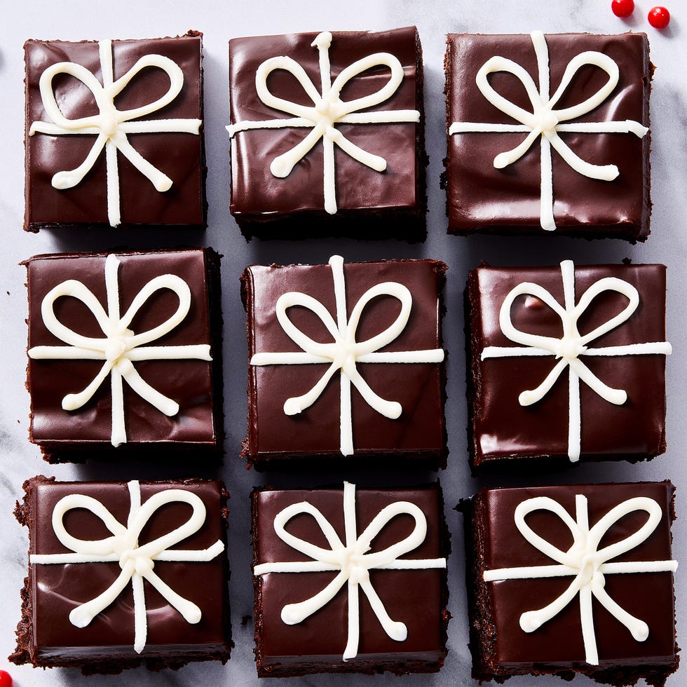 small brownies decorated with chocolate ganache and white icing to look like christmas presents