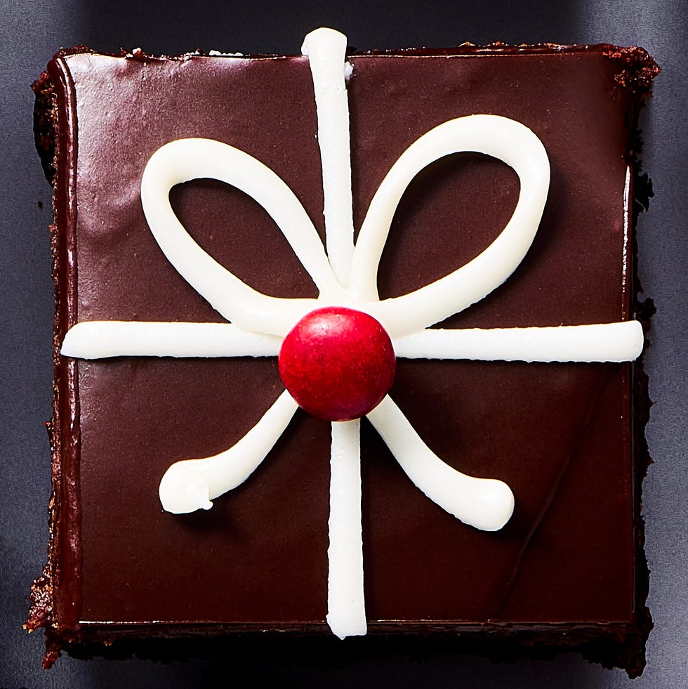 small brownies decorated with chocolate ganache and white icing to look like christmas presents