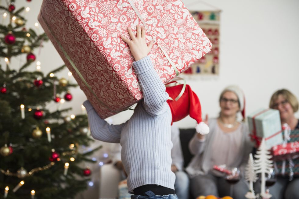 Little boy carrying big cardboard box during Christmas