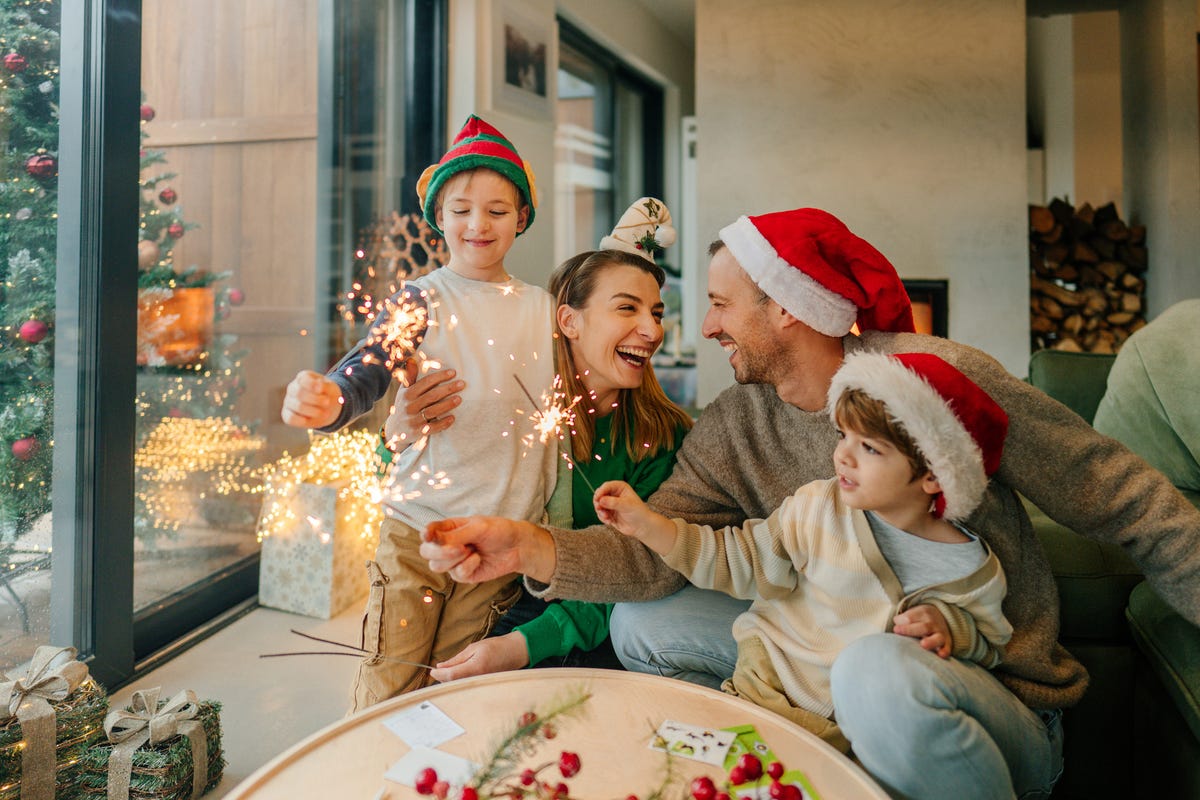 a family celebrating christmas with santa hats and sparklers