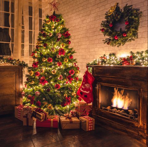 christmas tree near fireplace in decorated living room