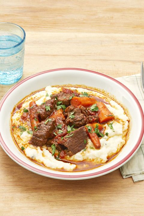 instant pot ancho beef stew over grits on wood background